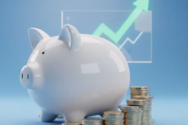 Ceramic piggy bank with British pound coins and growth arrow